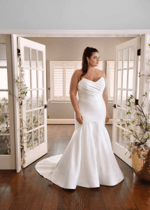 Bride smiling in mirror wearing wedding dress at Pawleys Island bridal shop during exclusive private Lowcountry appointment. Wedding dress shopping.