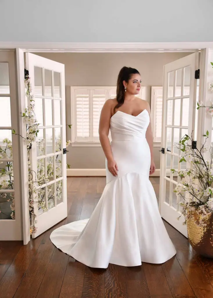 Bride smiling in mirror wearing wedding dress at Pawleys Island bridal shop during exclusive private Lowcountry appointment. Wedding dress shopping.