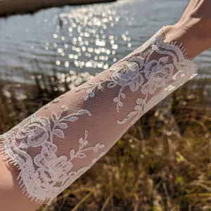 Long sleeve wedding dress detail, an illusion lace sleeve with light passing through onto the skin beneath.
